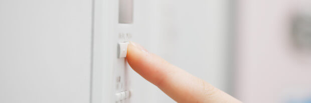 VIGILANT pressing a button on thermostat shutterstock